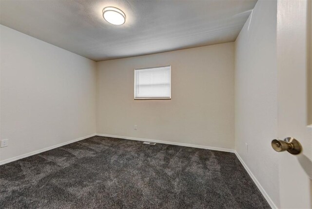 carpeted spare room featuring baseboards