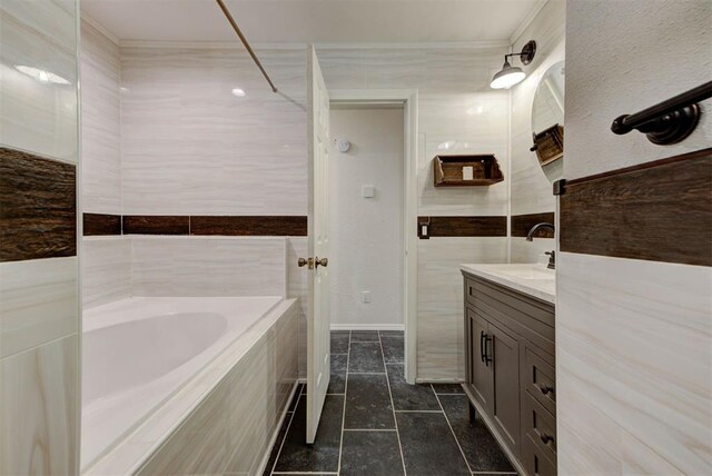 full bathroom featuring vanity, tile patterned flooring, and a tub to relax in