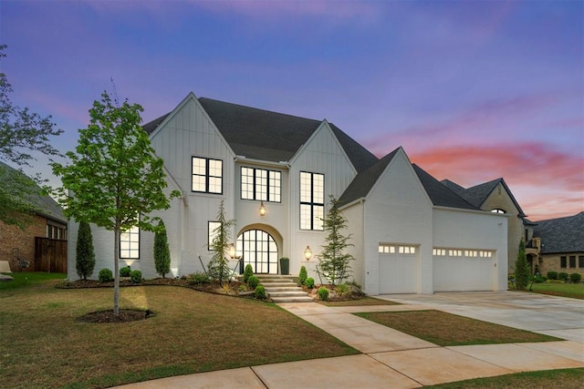view of front of house featuring an attached garage, board and batten siding, concrete driveway, and a lawn