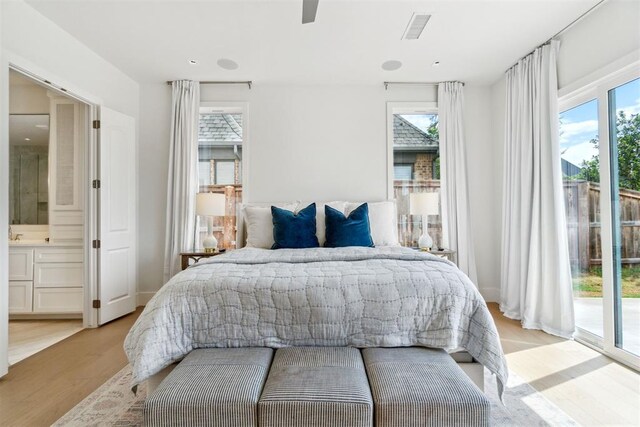 bedroom with recessed lighting, access to outside, light wood-type flooring, visible vents, and ensuite bathroom