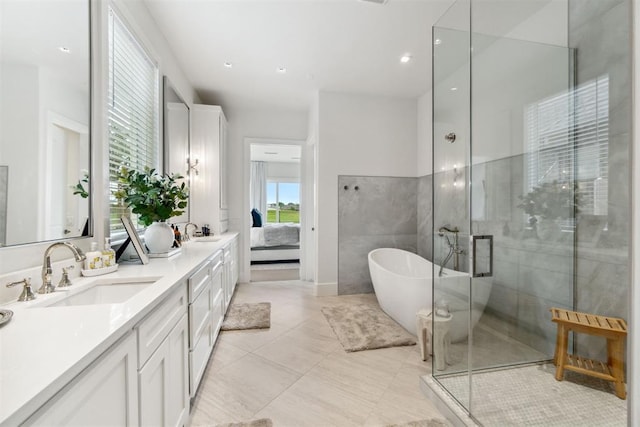 bathroom featuring a freestanding bath, a shower stall, double vanity, and a sink
