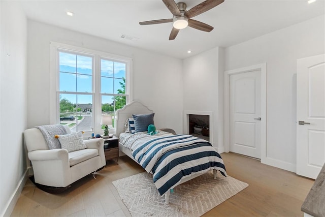 bedroom with recessed lighting, light wood-type flooring, a ceiling fan, visible vents, and baseboards