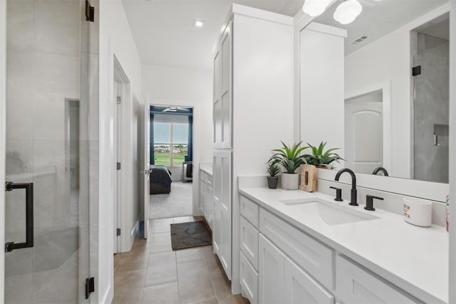 bathroom featuring tile patterned floors, a shower stall, ensuite bath, and vanity