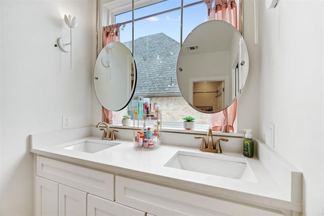 bathroom featuring double vanity, a sink, and visible vents