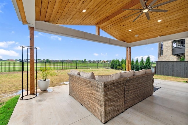 view of patio / terrace featuring a rural view, ceiling fan, an outdoor living space, and a fenced backyard