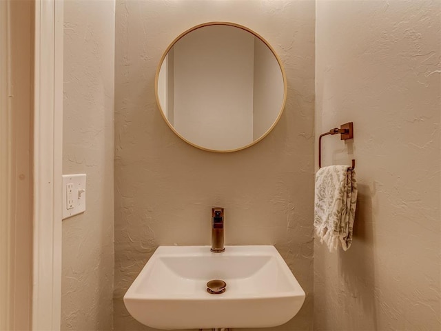 bathroom with a textured wall and a sink
