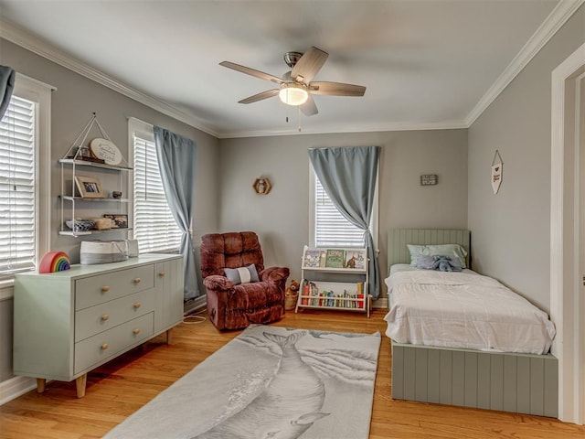 bedroom featuring crown molding, light wood finished floors, and ceiling fan
