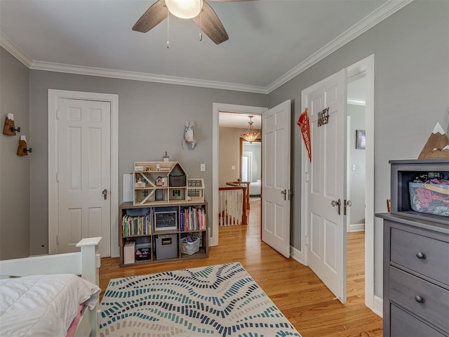 bedroom featuring light wood finished floors, a ceiling fan, ornamental molding, and baseboards