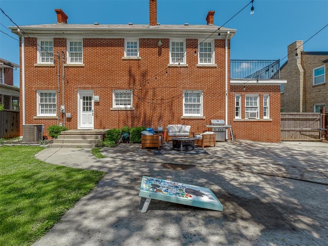 back of house with a patio, a chimney, an outdoor living space, fence, and brick siding