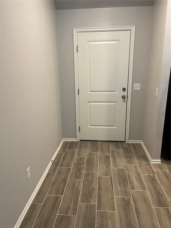 doorway featuring wood tiled floor and baseboards