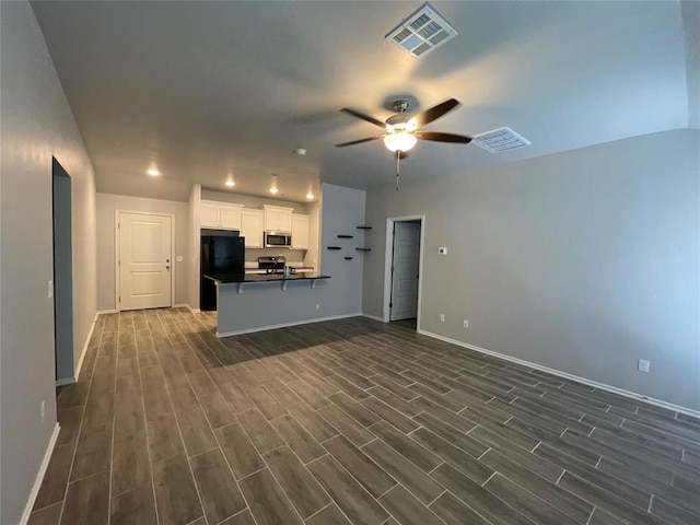 unfurnished living room featuring baseboards, ceiling fan, dark wood-style flooring, and visible vents