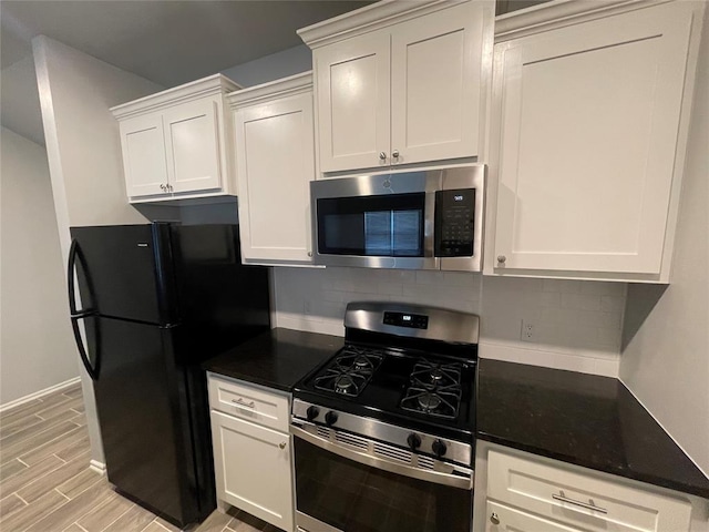 kitchen featuring white cabinets, tasteful backsplash, dark countertops, and stainless steel appliances