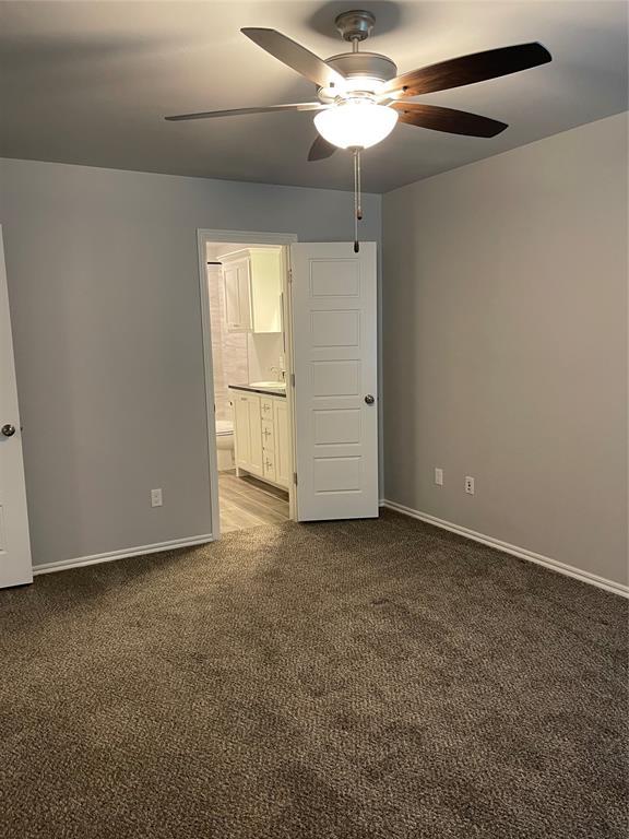unfurnished bedroom with baseboards, ceiling fan, carpet, and ensuite bath