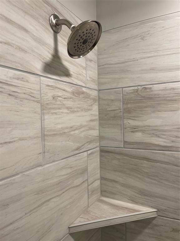 interior details featuring tiled shower