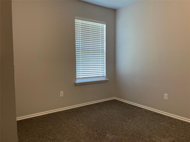 spare room featuring baseboards and carpet