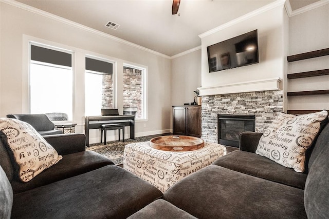 living area featuring ornamental molding, ceiling fan, a stone fireplace, baseboards, and visible vents