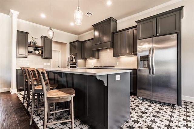 kitchen with open shelves, stovetop, visible vents, light countertops, and stainless steel fridge