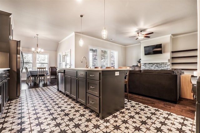 kitchen with tile patterned floors, light countertops, pendant lighting, freestanding refrigerator, and ceiling fan with notable chandelier