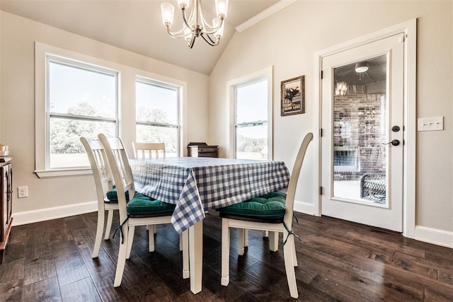 dining space featuring lofted ceiling, dark wood-style flooring, a chandelier, and baseboards