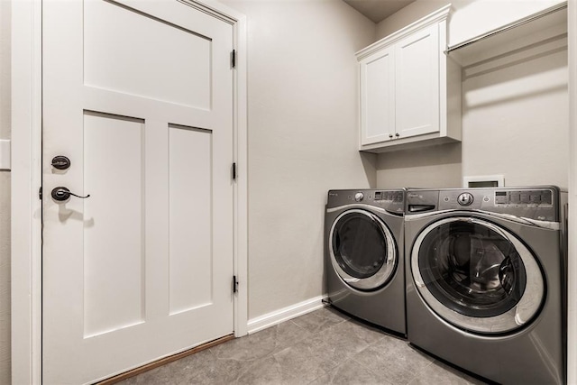 laundry room featuring washing machine and clothes dryer, cabinet space, and baseboards