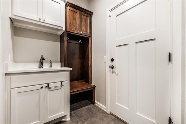 mudroom with baseboards and a sink