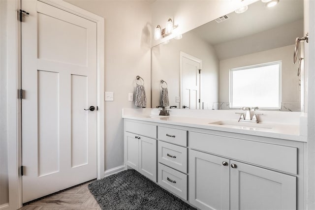 bathroom featuring double vanity, visible vents, and a sink
