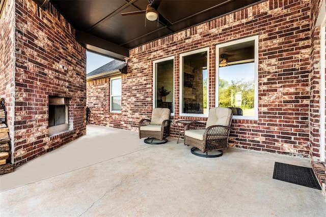 view of patio featuring a ceiling fan and an outdoor brick fireplace