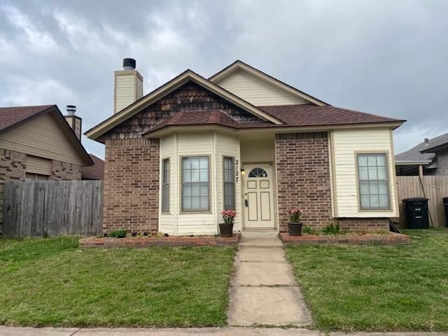 bungalow-style home with brick siding, a front lawn, and fence