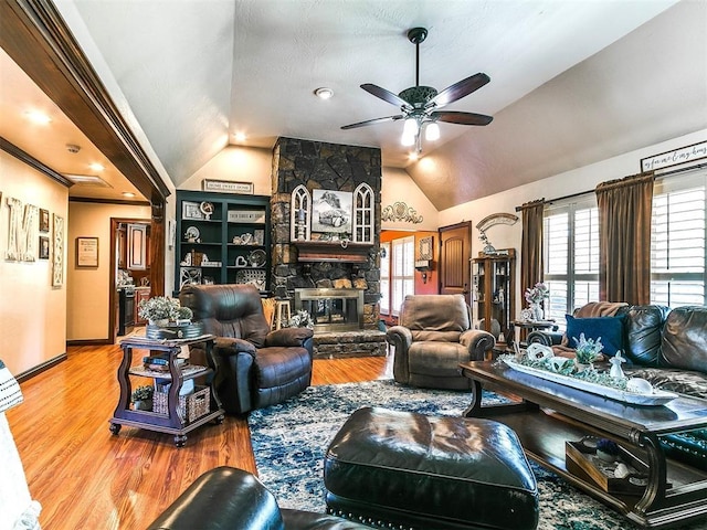 living area with plenty of natural light, a ceiling fan, wood finished floors, and vaulted ceiling