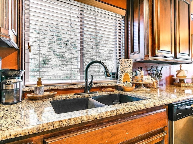 kitchen with light stone counters, a sink, a healthy amount of sunlight, and stainless steel dishwasher
