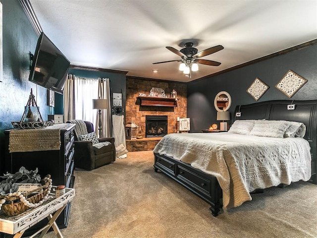 bedroom with carpet flooring, a stone fireplace, ornamental molding, and ceiling fan