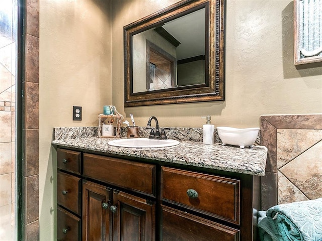 bathroom with vanity and a textured wall