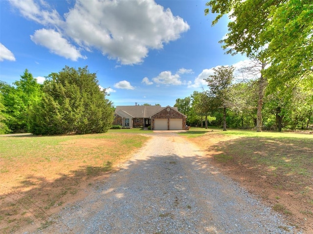 view of front facade featuring an attached garage, stone siding, and gravel driveway