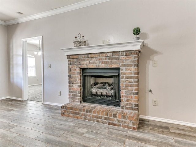 details featuring crown molding, a fireplace, baseboards, wood tiled floor, and ceiling fan