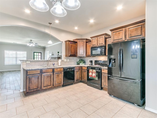 kitchen with a peninsula, ceiling fan, brown cabinets, backsplash, and black appliances