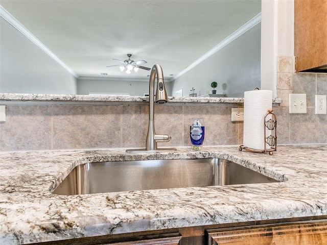 details with a sink, ceiling fan, tasteful backsplash, and ornamental molding