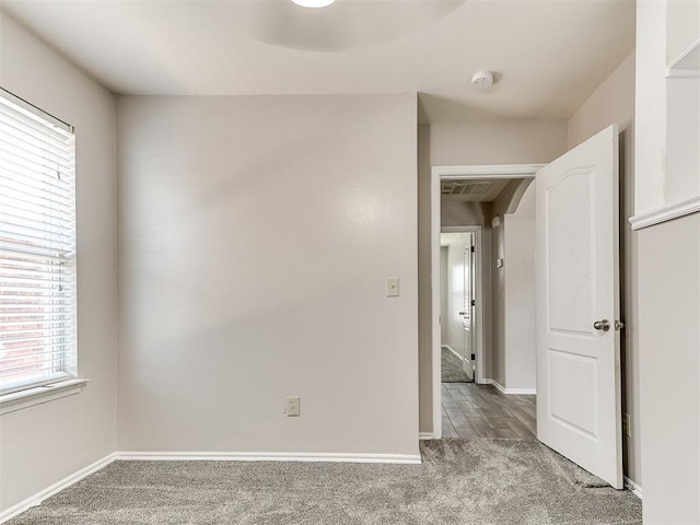 spare room featuring carpet floors and baseboards