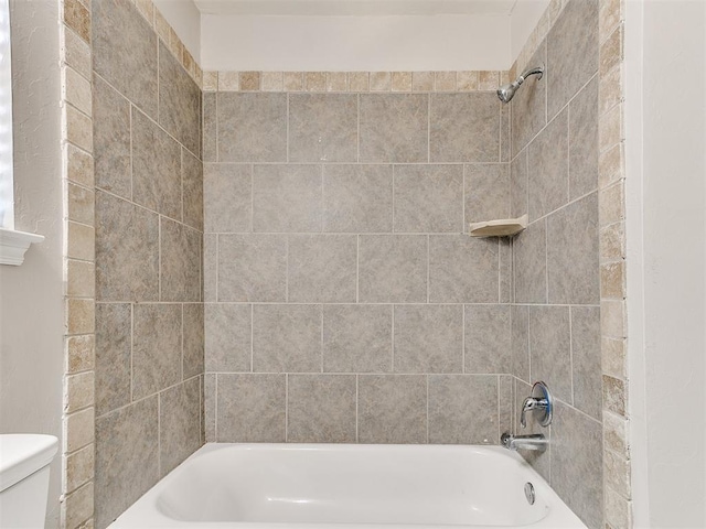 bathroom with washtub / shower combination and toilet