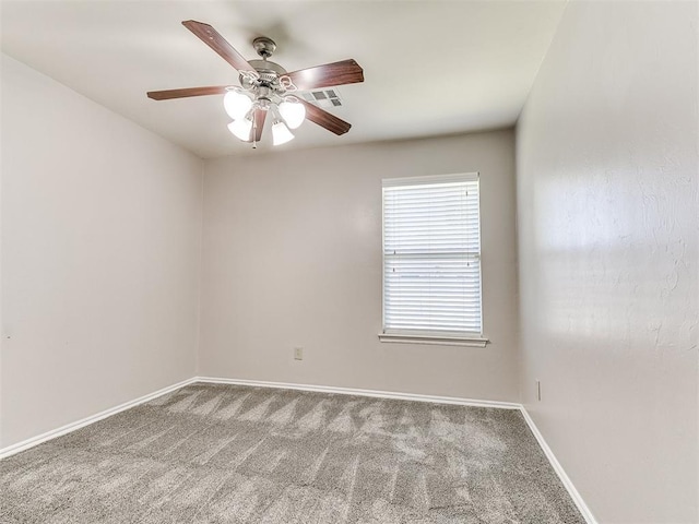 carpeted spare room with a ceiling fan, baseboards, and visible vents