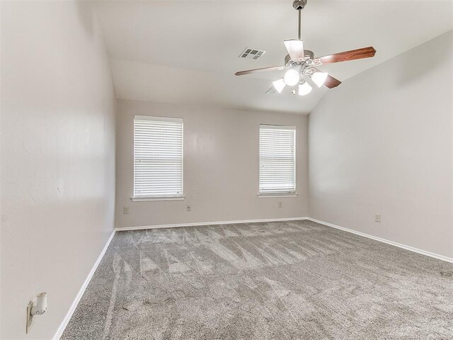 empty room with baseboards, carpet flooring, lofted ceiling, and a wealth of natural light