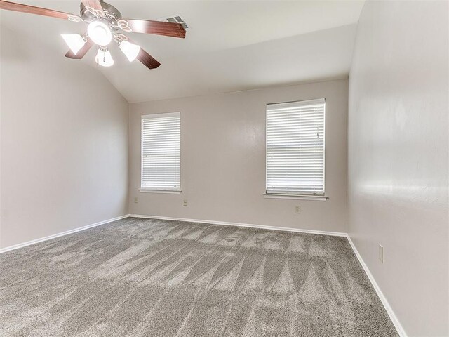 carpeted empty room with a healthy amount of sunlight, baseboards, visible vents, and lofted ceiling