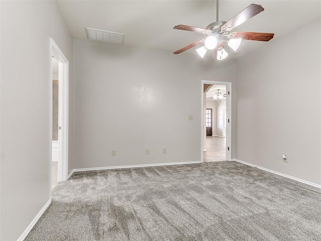 empty room featuring visible vents, a ceiling fan, carpet, and attic access