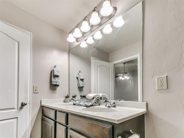 full bathroom with a sink, a textured wall, and double vanity