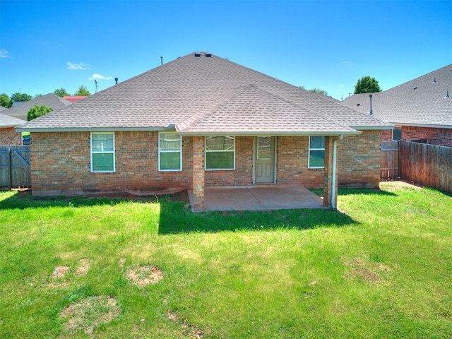 back of property featuring roof with shingles, a fenced backyard, a patio area, and brick siding