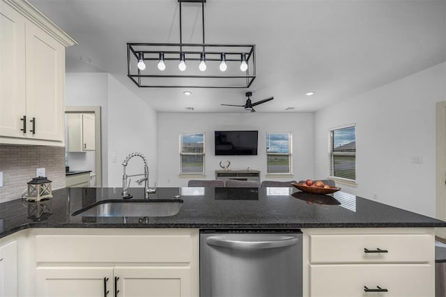 kitchen featuring white cabinetry, tasteful backsplash, stainless steel dishwasher, a sink, and open floor plan