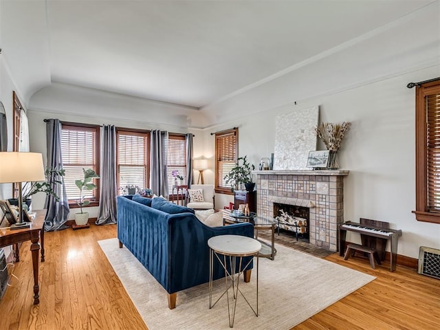 living room with light wood-type flooring, visible vents, and a fireplace