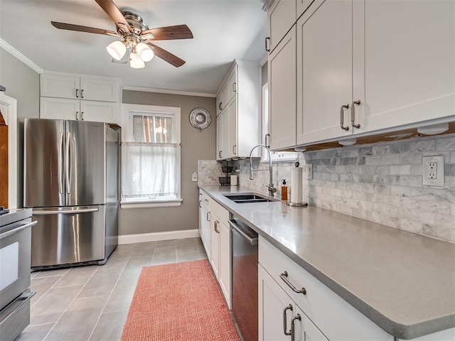 kitchen with decorative backsplash, a ceiling fan, appliances with stainless steel finishes, a sink, and ornamental molding