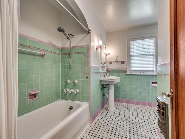 bathroom featuring tile walls, wainscoting, and shower / tub combo with curtain