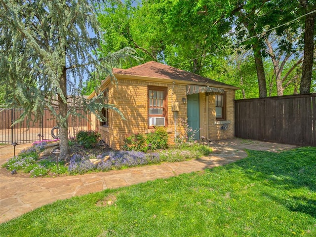 exterior space with brick siding, fence, and a front yard
