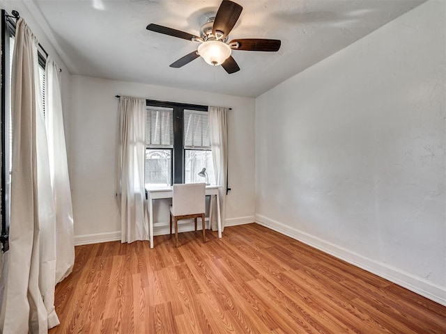 empty room with baseboards, light wood-style flooring, and ceiling fan